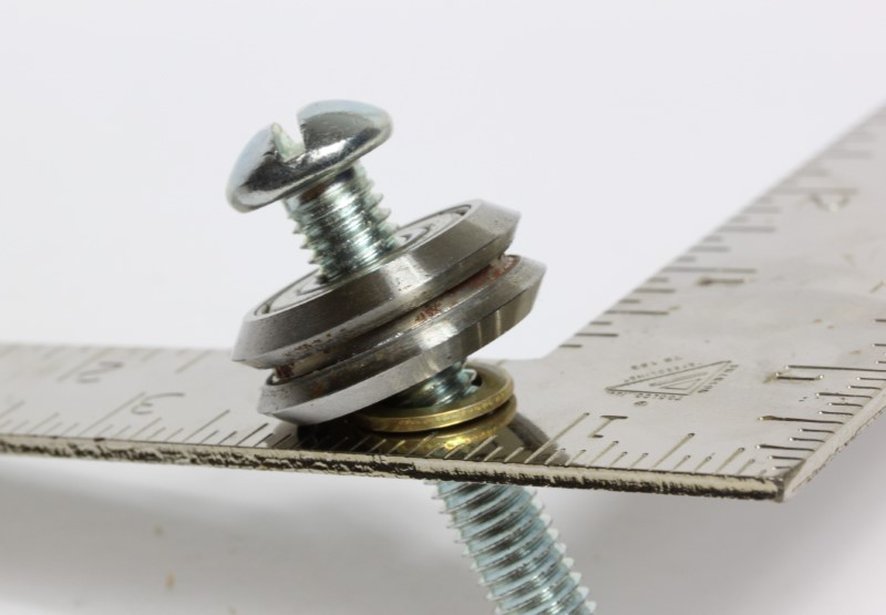 3-8 Inch Shim Washer shown on a screw with bearing on a metal plate.